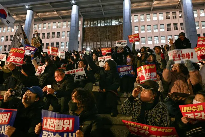 12月4日，韩国民众在首尔的国会大厦台阶上参加抗议活动，要求总统尹锡悦辞职。新华社/法新