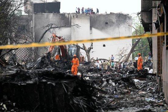 当地时间6月13日，艾哈迈达巴德，印度国家灾害响应部队人员在坠机现场进行检查。图/视觉中国
