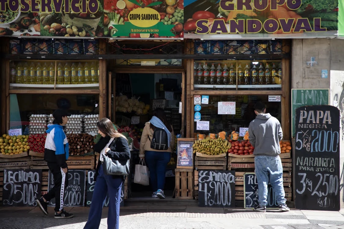 9月25日，在阿根廷首都布宜诺斯艾利斯，人们走过一家张贴着特价广告的蔬果店。新华社发（马丁·萨巴拉摄）