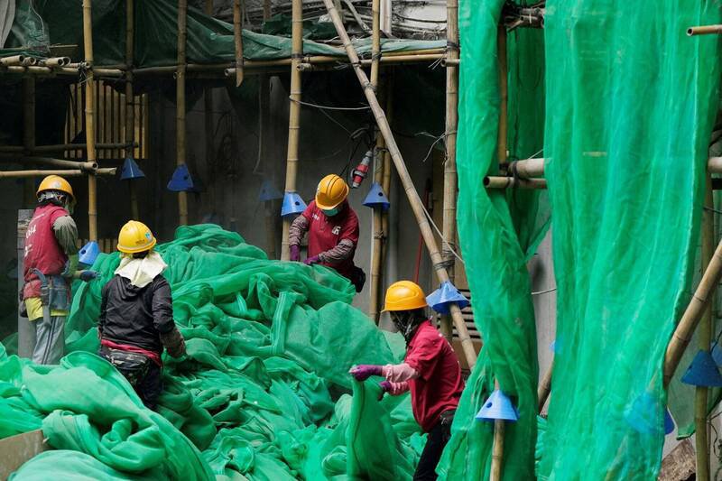 香港大埔宏福苑火灾伤亡惨重，穗禾苑工人违规吸烟被开除。图为穗禾苑拆除防护网。（路透）