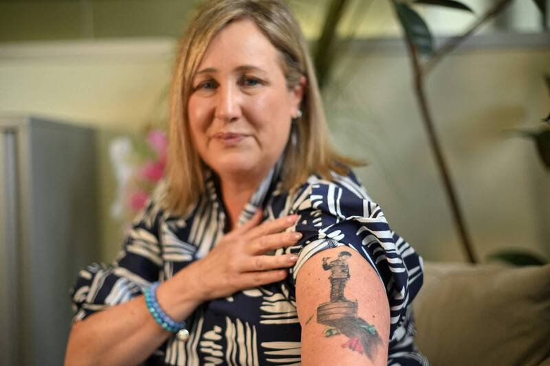 澳洲母亲班尼斯特（Mia Bannister）展示手臂上纪念亡儿奥利的刺青。14岁的奥利因遭受网路霸凌轻生，促使她致力推动澳洲实施未满16岁禁用社群媒体的法案，以此保护下一代。（法新社）