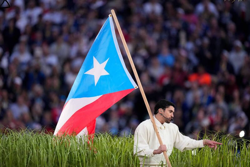 坏痞兔于表演中高举「与波多黎各独立运动相关的国旗」(浅蓝色元素,而非波多黎各官方国旗的标准深蓝色),暗指1948年颁布的「封口法」。(美联社) 坏痞兔于表演中高举「与波多黎各独立运动相关的国旗」(浅蓝色元素,而非波多黎各官方国旗的标准深蓝色),暗指1948年颁布的「封口法」。(美联社)