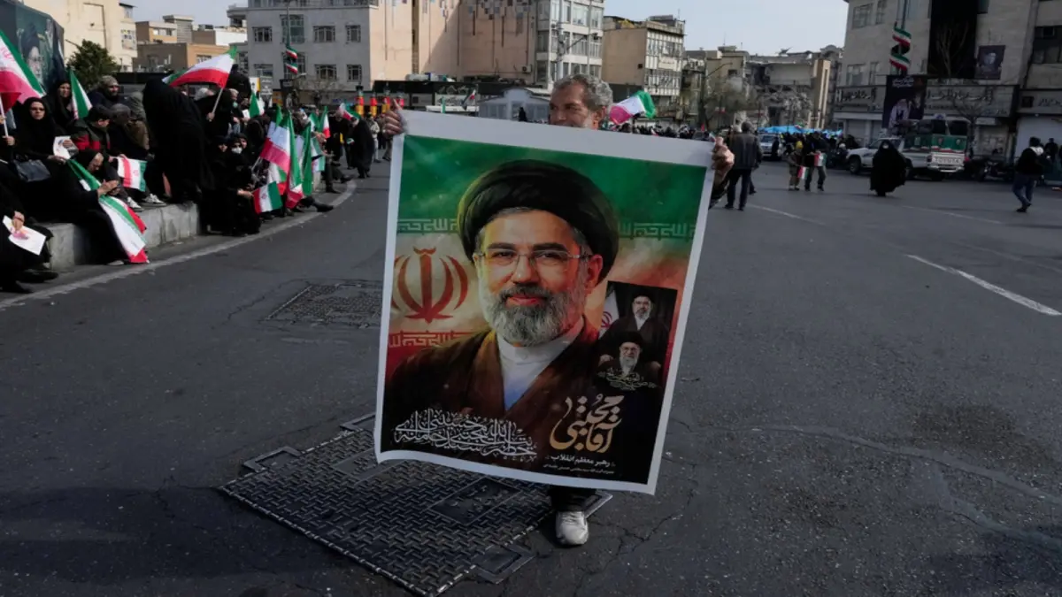 ▲伊朗最高领袖穆吉塔巴（Mojtaba Khamenei）9日再度透过官媒发表声明。 图为德黑兰街头的支持者，手持穆吉塔巴的照片。 （图/美联社/达志影像）